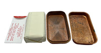 A pair of vintage copper trays shown side-by-side with their cream-colored fabric lining and a white paper envelope with red text, all arranged on a plain white background.