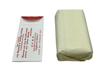 A vintage first aid kit component, specifically a white paper instruction card with red text next to its pale yellow paper-wrapped package, displayed on a white surface.